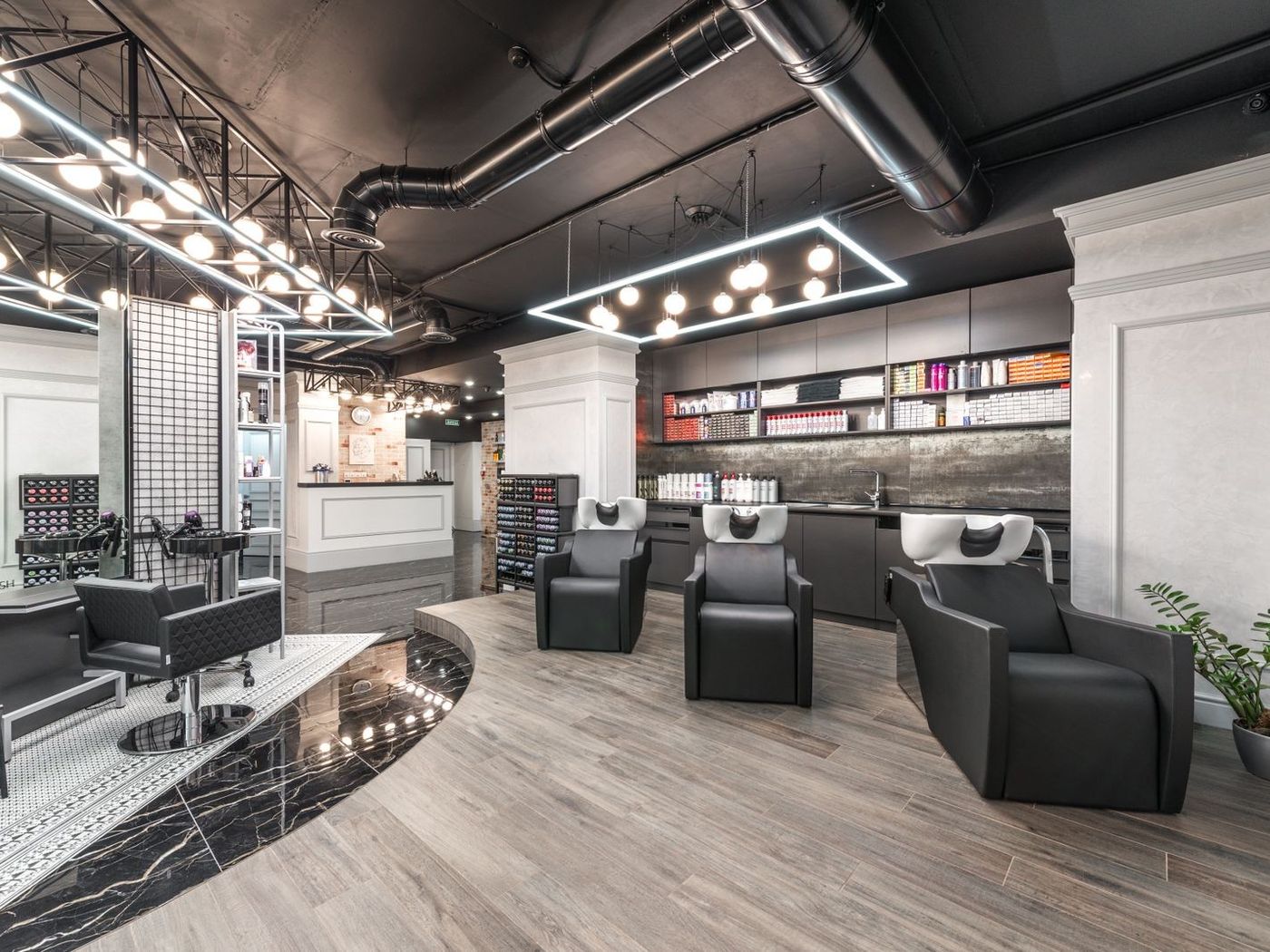 Salon de coiffure : les postes de travail alignés devant les miroirs.
